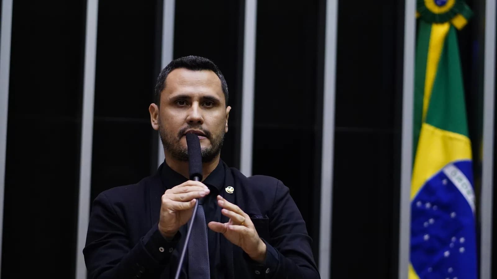 Cleitinho Azevedo discursa no plenário com a mão levantada, microfone à frente
