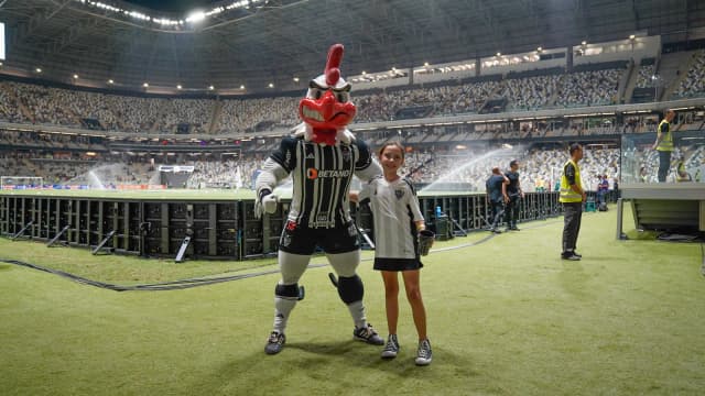 Mascote do Atlético-MG posa com torcedora mirim no gramado da Arena MRV