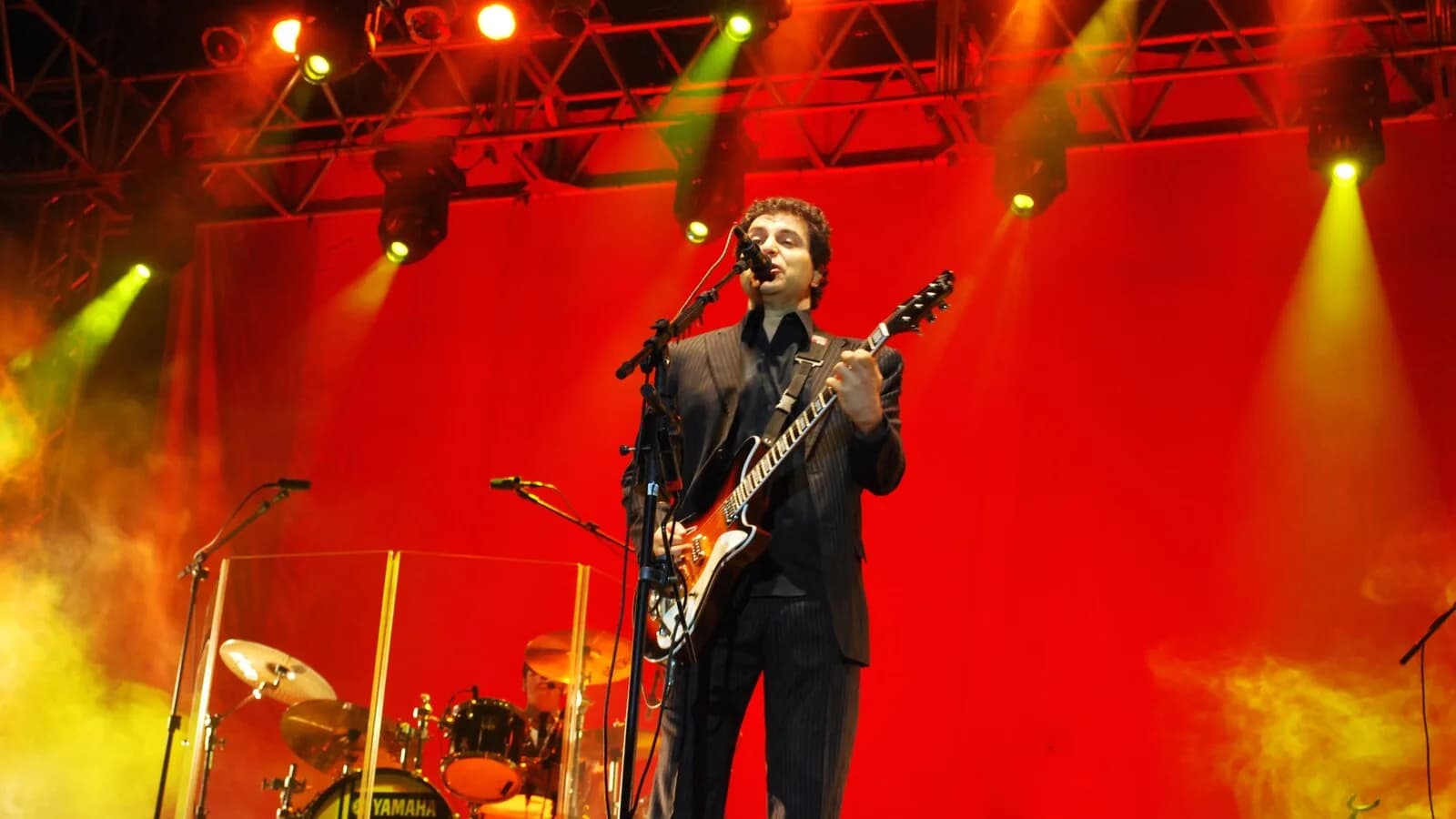 Frejat cantando ao vivo em show, com luzes vermelhas no palco