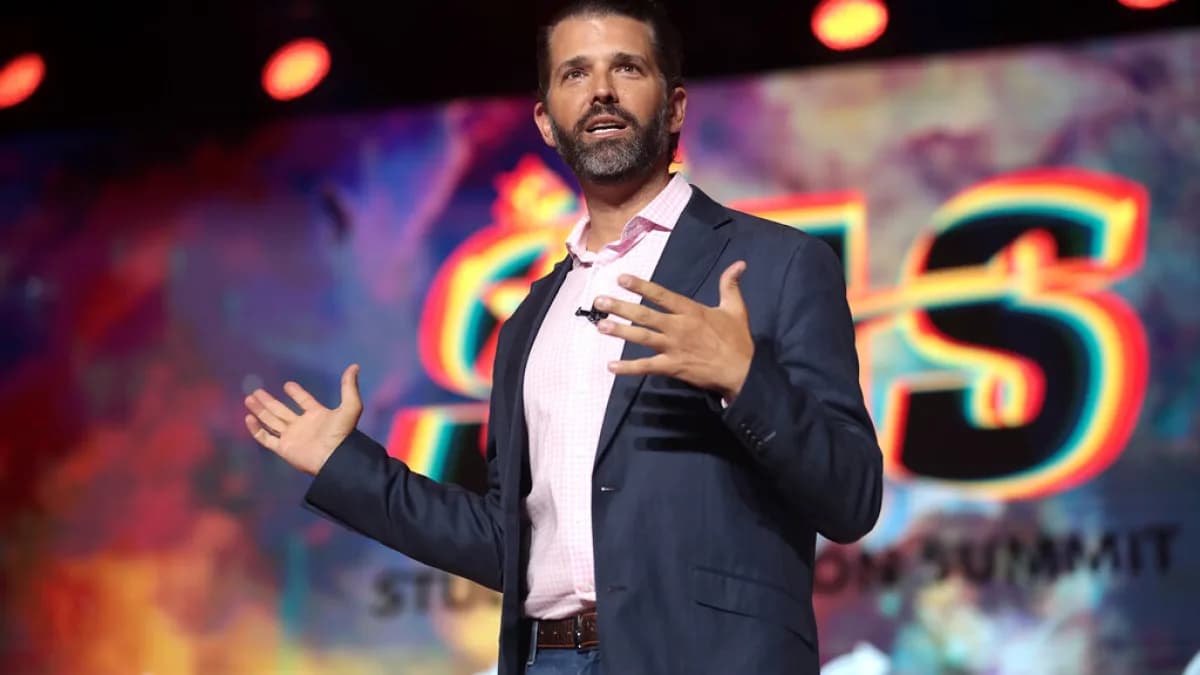 Donald Trump Jr. discursa em evento, vestindo terno escuro