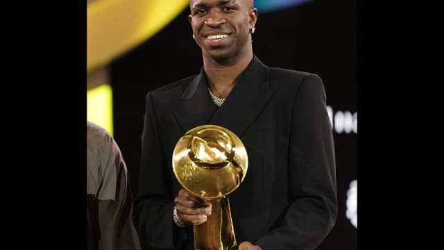 Vini Jr sorri segurando troféu de melhor jogador do mundo do Globe Soccer Awards