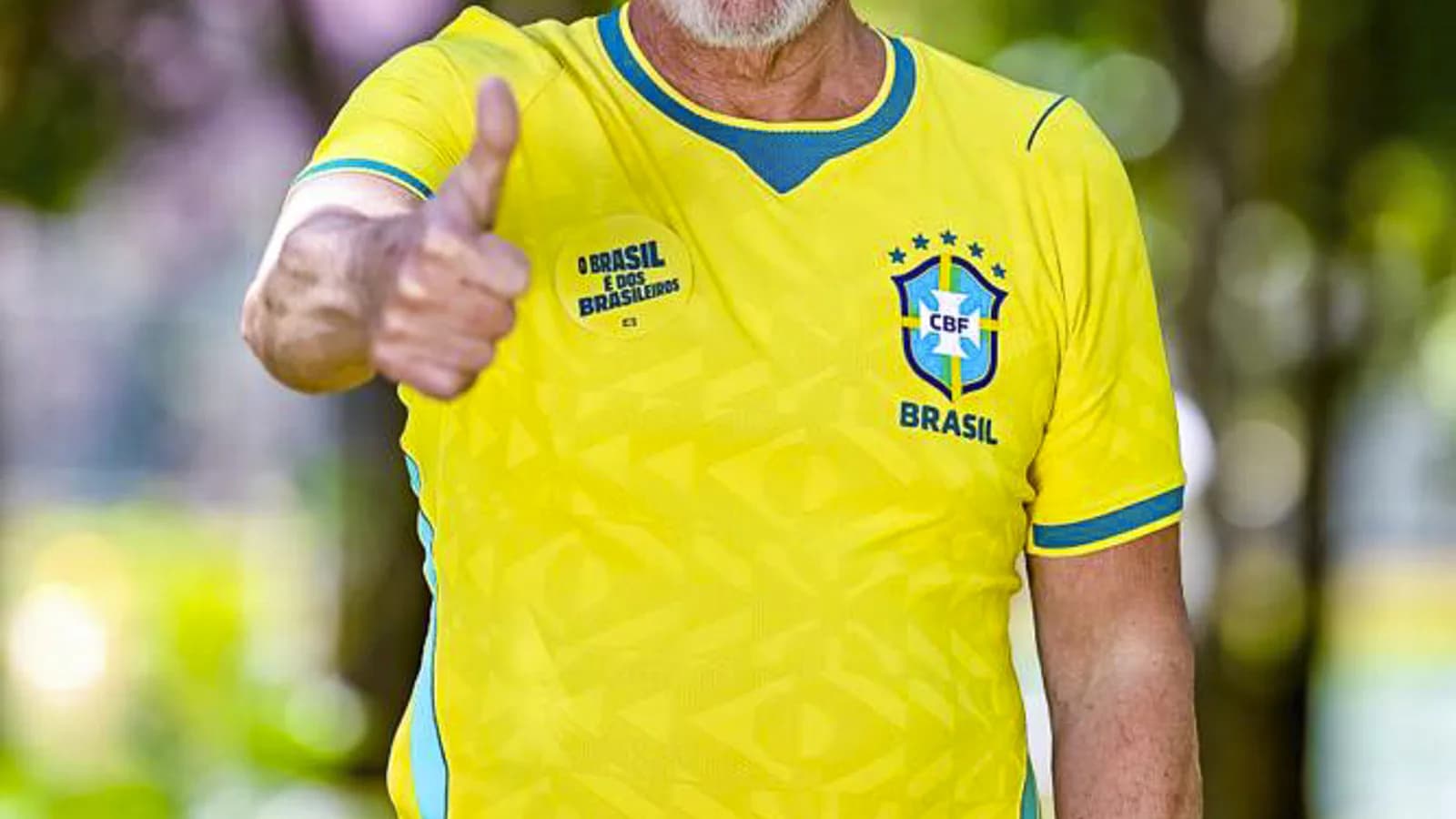 Lula sorri com os polegares para cima, vestindo camisa da Seleção Brasileira