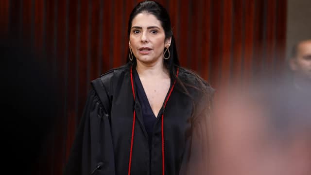 A ministra do TSE Estela Aranha, de toga preta com detalhes vermelhos, durante cerimônia de posse