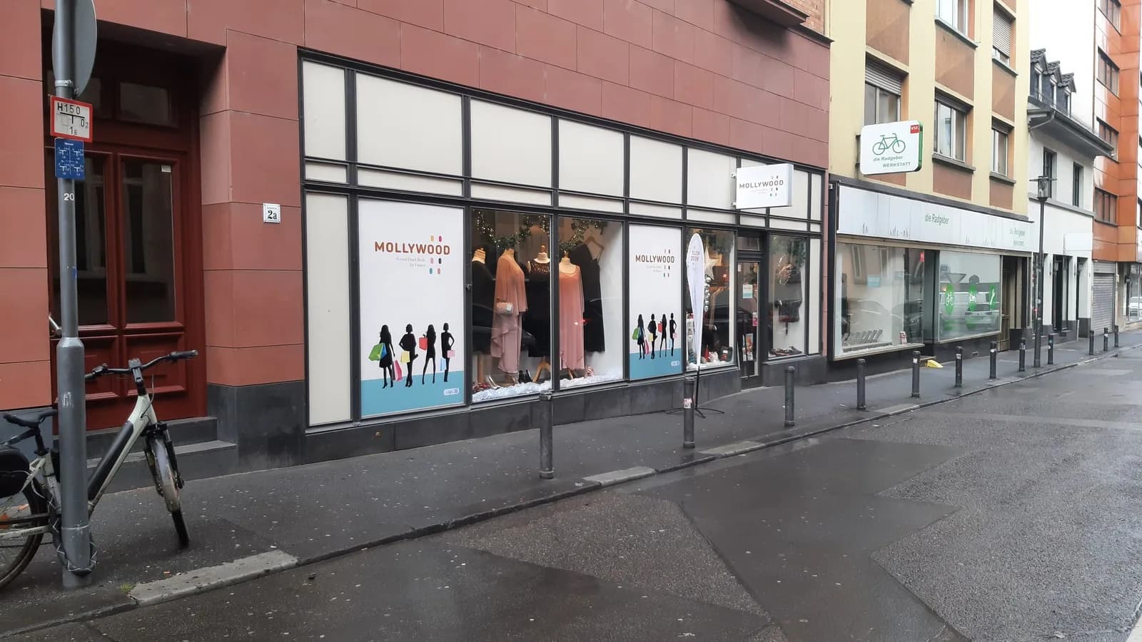Fachada de loja de roupas de segunda mão com vitrine exibindo peças