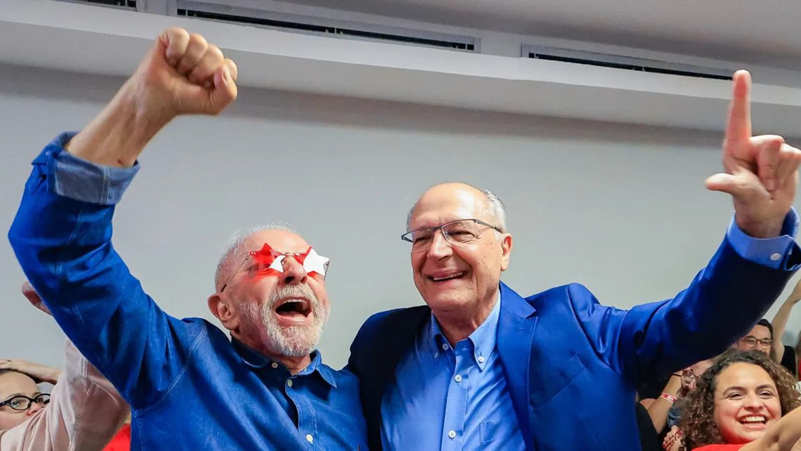 Lula e Alckmin erguem o punho ao lado de apoiadores em comemoração à reeleição