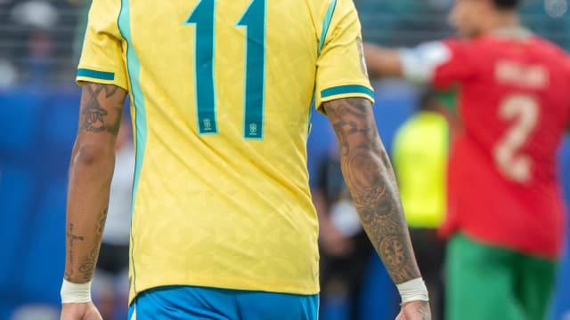 Raphinha visto de costas, com o nome e o número 11 na camisa da seleção brasileira