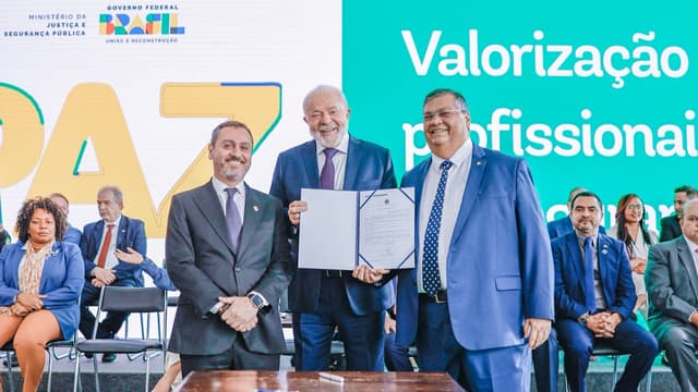 Foto de arquivo de julho de 2023: o presidente Lula segura um documento assinado ao lado do diretor-geral da Polícia Federal, Andrei Rodrigues, à esquerda, e do então ministro da Justiça e Segurança Pública, Flávio Dino, à direita, no Palácio do Planalto