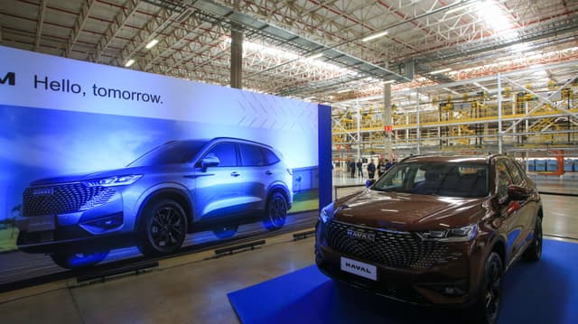 SUV Haval, marca do grupo chinês GWM, em exibição na fábrica da montadora em Iracemápolis (SP), com linha de produção ao fundo