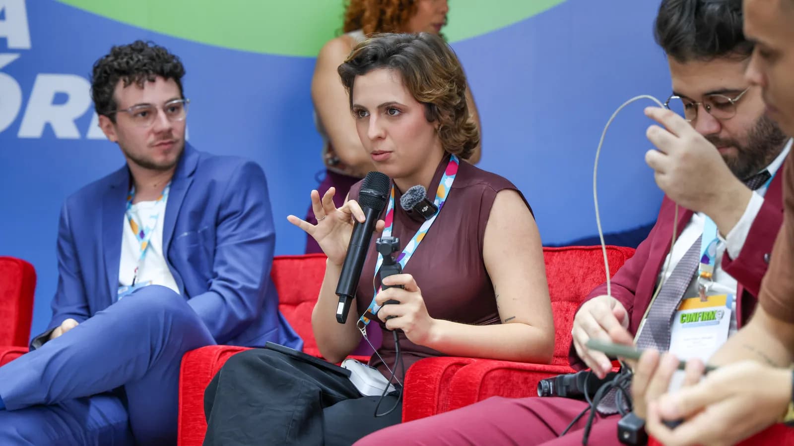 Painel de debate sobre TSE e influenciadores digitais, com participantes sentados em sofás vermelhos