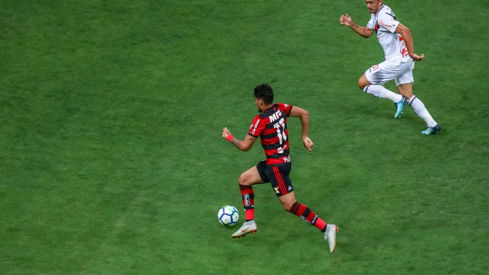Jogador do Flamengo conduz a bola em campo durante partida (foto de arquivo)
